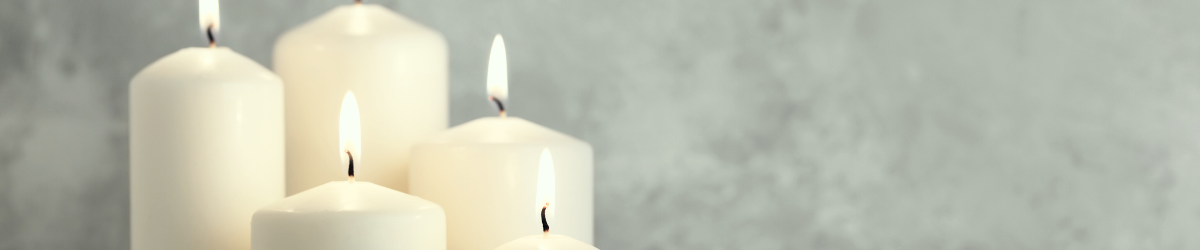 Five lit white pillar candles on a soft grey background.