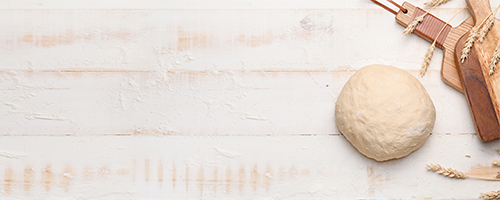 A ball of bannock dough beside some wooden cutting boards.
