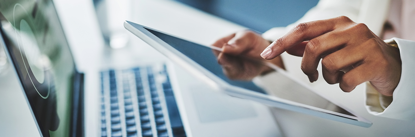 Hands typing on a tablet.